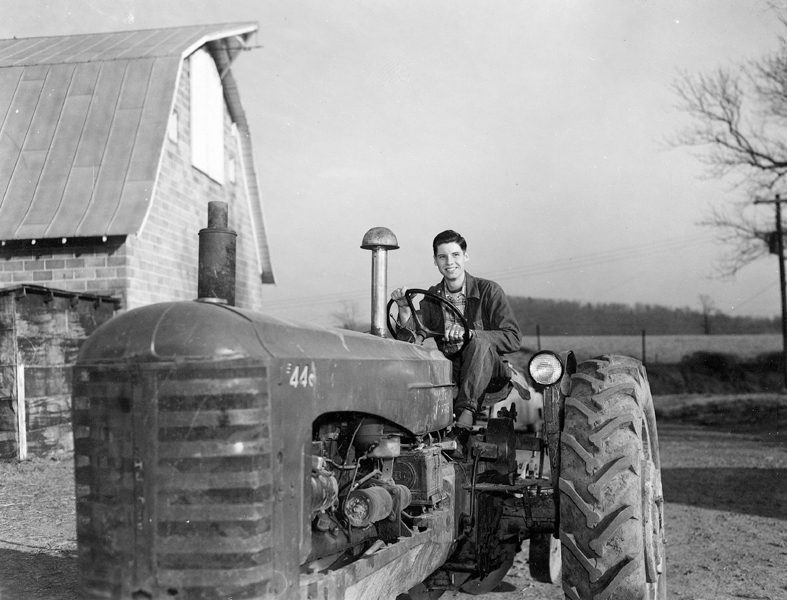Black and white image of a man on a tractor
